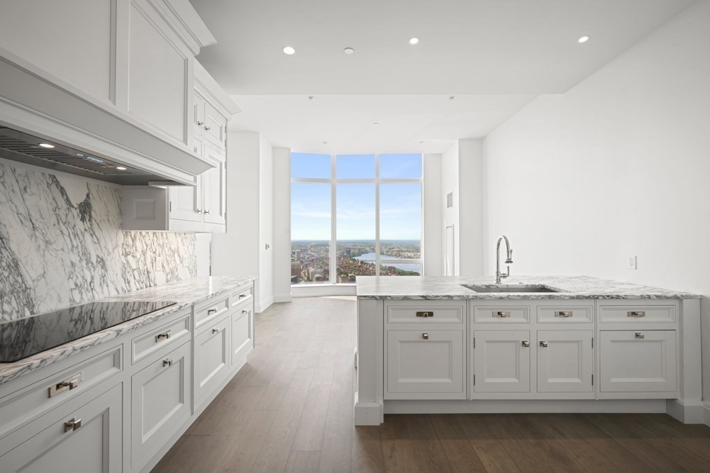240 Devonshire Street, Unit PH 2C Boston, MA 02110 - Photo 6 of 42 a large white kitchen with granite countertop a large window and white stainless steel appliances