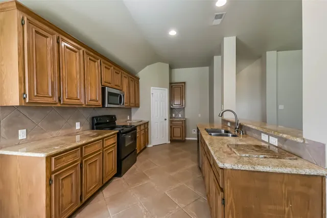 a kitchen with stainless steel appliances granite countertop a sink stove and cabinets