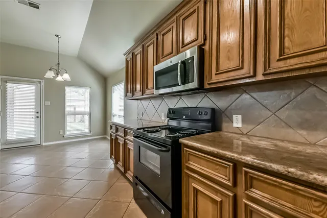 a kitchen with stainless steel appliances granite countertop a stove and a microwave