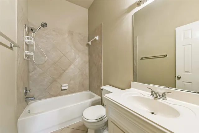a bathroom with a bathtub shower sink mirror vanity and toilet