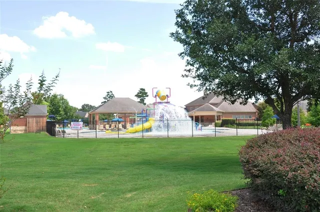 a view of a house with a big yard and large trees