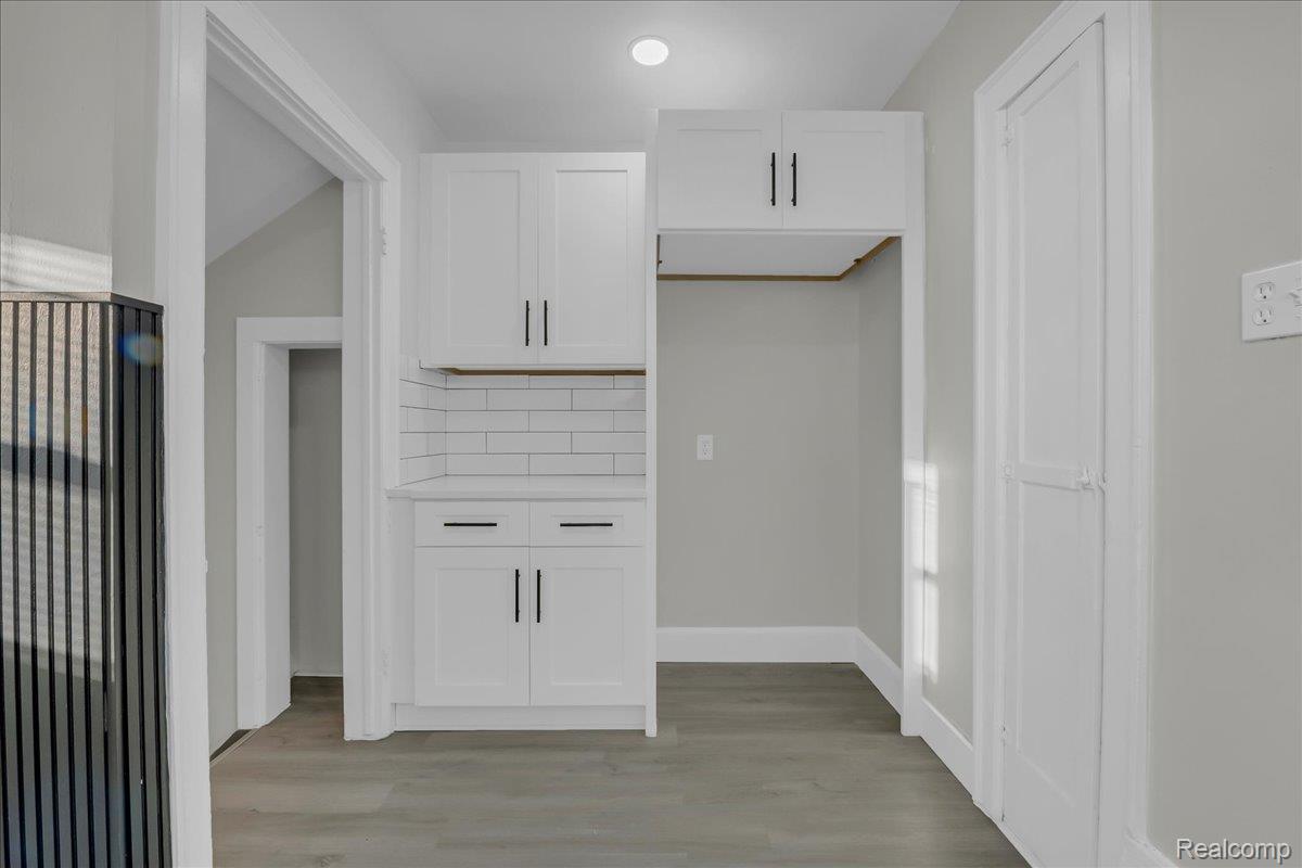 16717 Fielding Street Detroit, MI 48219 - Photo 21 of 46 Kitchen featuring white cabinetry, light wood-type flooring, and backsplash