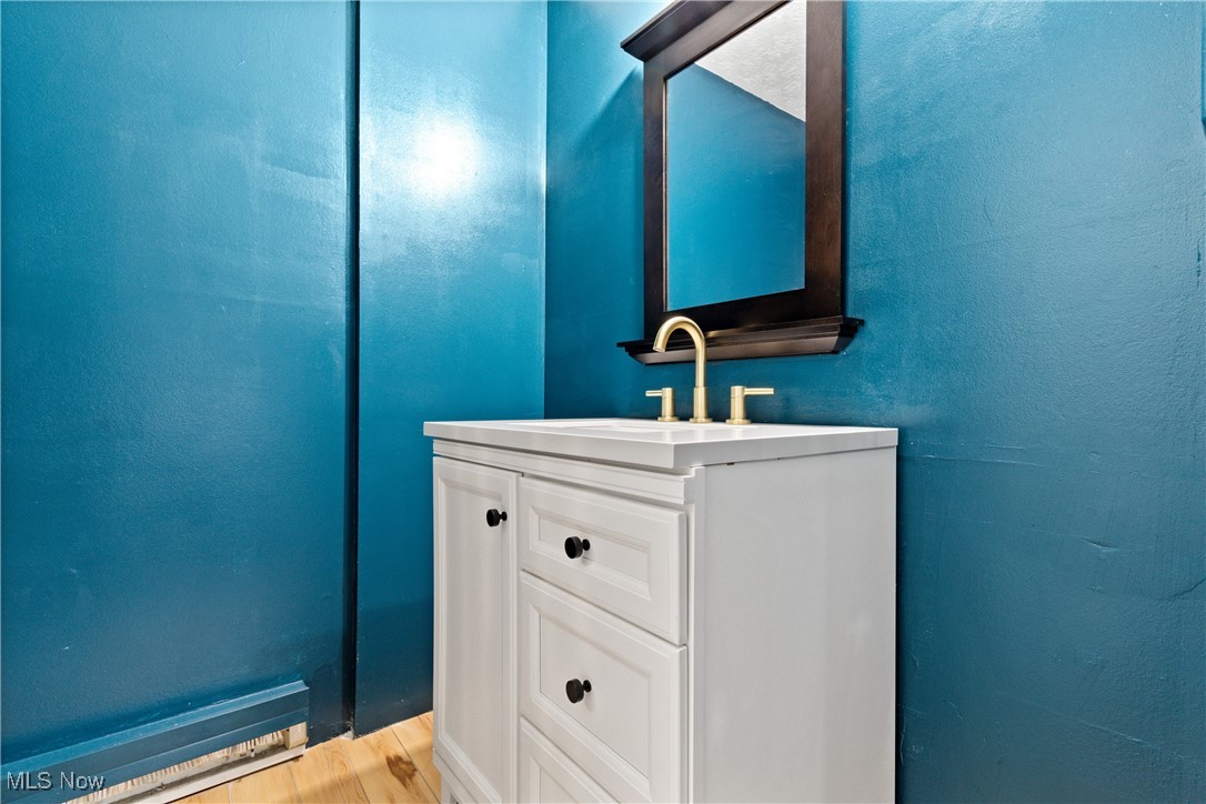 9956 Johnnycake Ridge Road, Unit F4 Painesville, OH 44077 - Photo 18 of 25 Bathroom featuring hardwood / wood-style floors and vanity