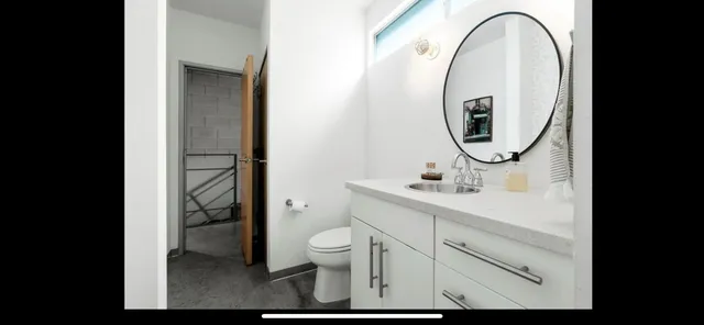 a bathroom with a toilet sink and mirror