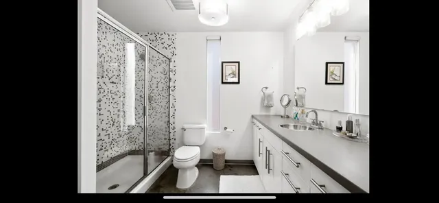 a bathroom with a double vanity sink toilet and shower