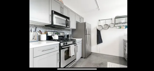 a kitchen with stainless steel appliances granite countertop a stove a refrigerator and a microwave