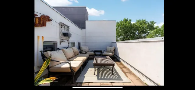 a view of a balcony with chairs and a potted plant