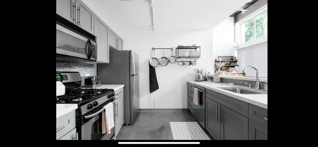 a kitchen with stainless steel appliances granite countertop a stove a sink and a refrigerator