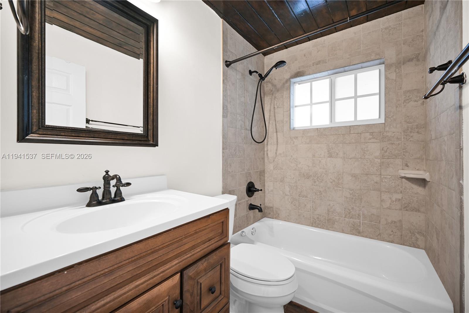 6560 Southwest 39th Street Miami, FL 33155 - Photo 7 of 17 a bathroom with a sink vanity mirror bathtub and toilet