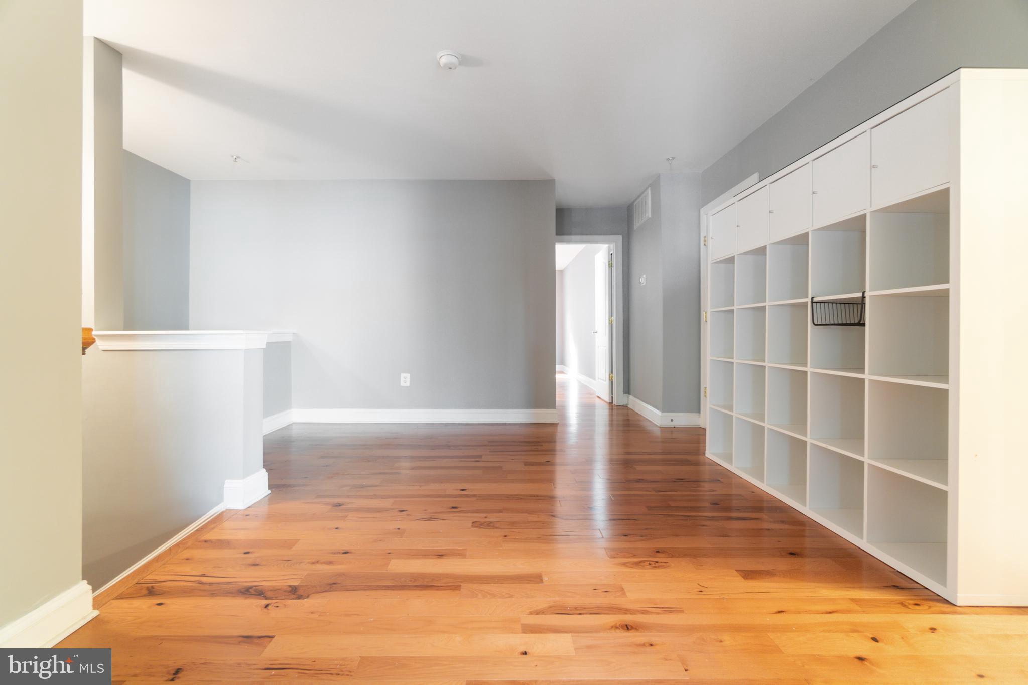 104 Bucksfield Road, Unit 104 Gaithersburg, MD 20878 - Photo 12 of 39 a view of an empty room with wooden floor and a window