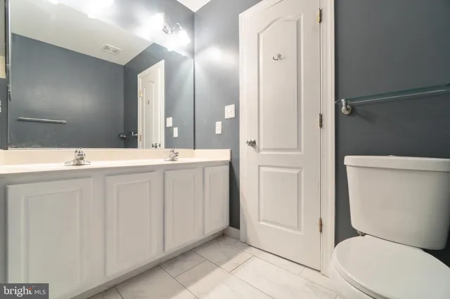 a bathroom with a sink a toilet a mirror and shower