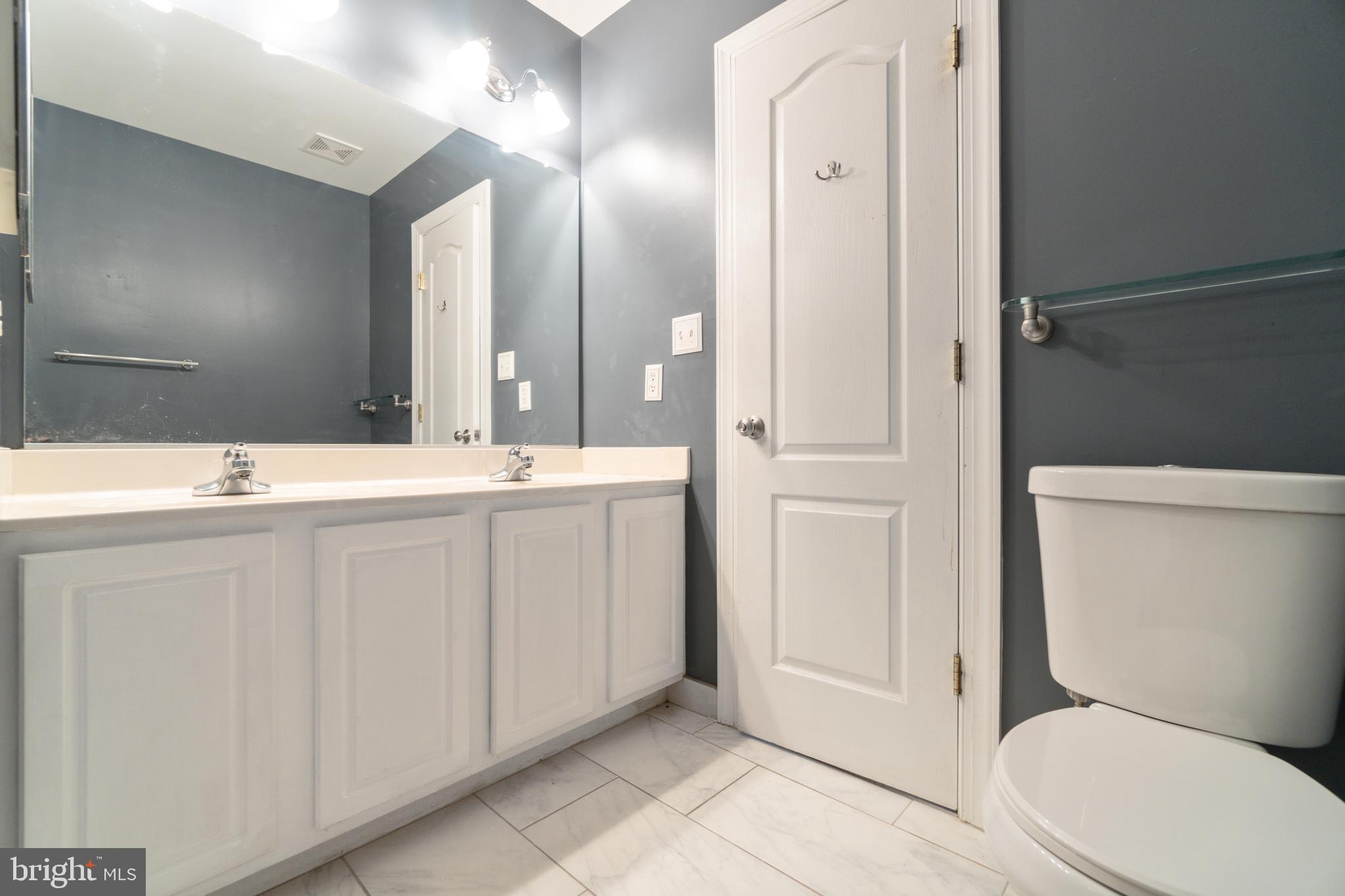 104 Bucksfield Road, Unit 104 Gaithersburg, MD 20878 - Photo 17 of 39 a bathroom with a sink a toilet a mirror and shower