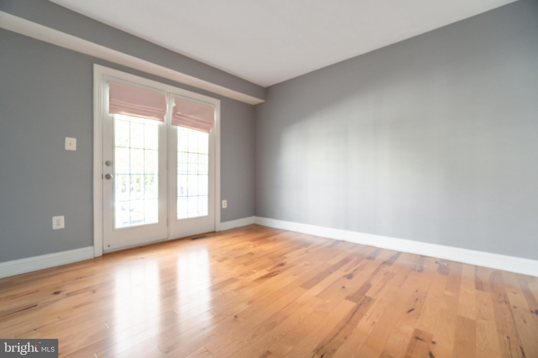 104 Bucksfield Road, Unit 104 Gaithersburg, MD 20878 - Photo 28 of 39 a view of an empty room with wooden floor and a window