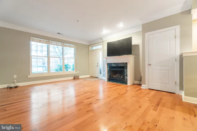 a view of an empty room with a fireplace and a window