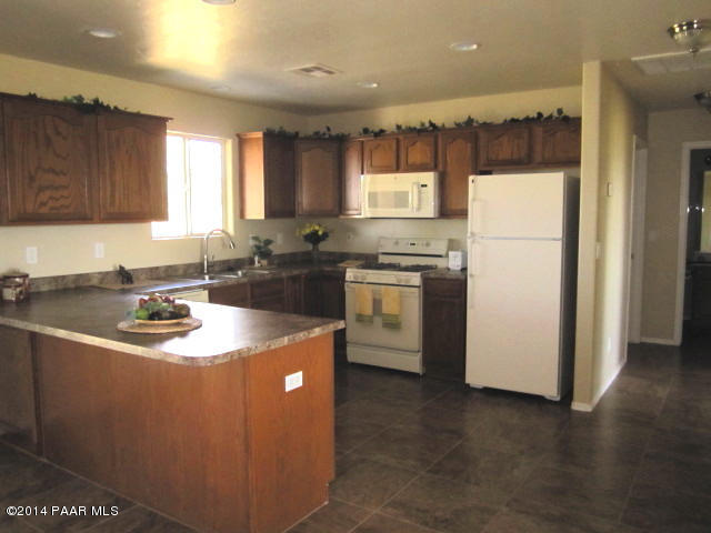 850 West Iris Road Paulden, AZ 86334 - Photo 7 of 17 a kitchen with stainless steel appliances granite countertop a sink a stove a refrigerator and a refrigerator