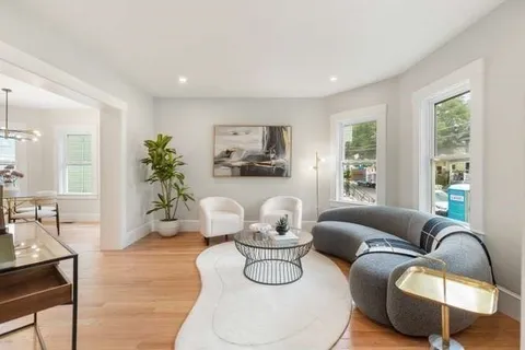 a living room with furniture potted plant and window