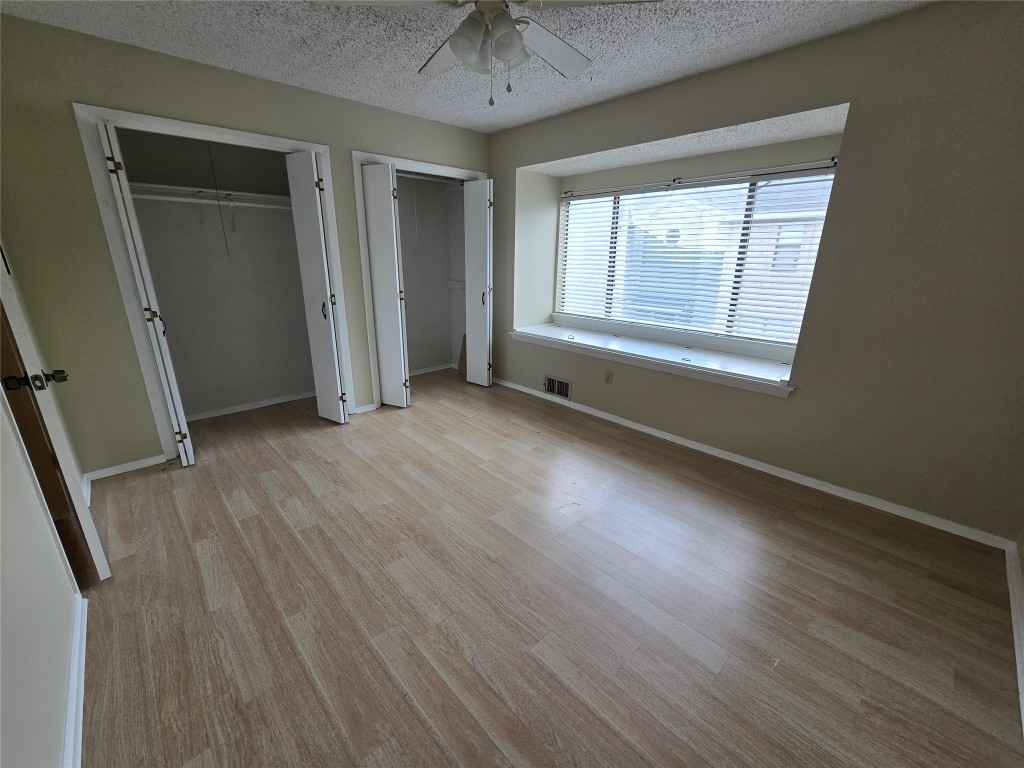 1221 Hopkins Street, Unit 8 San Marcos, TX 78666 - Photo 4 of 14 an empty room with wooden floor and windows