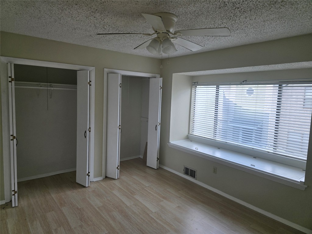 1221 Hopkins Street, Unit 8 San Marcos, TX 78666 - Photo 5 of 14 an empty room with wooden floor and windows