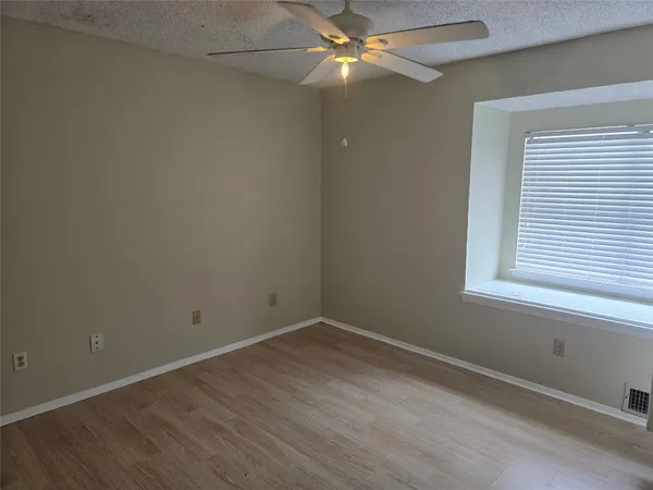 an empty room with a window and wooden floor