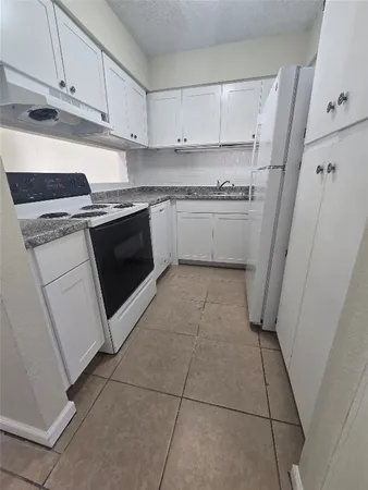 a kitchen with a stove top oven sink and cabinets