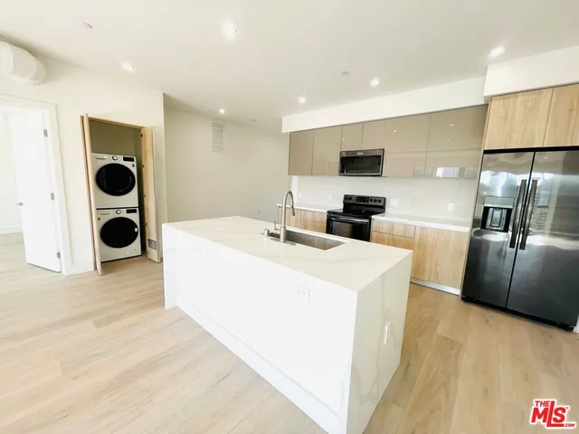 a kitchen with stainless steel appliances a refrigerator sink and microwave