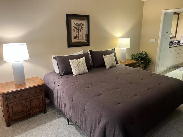 a large bed sitting in a bedroom next to a lamp