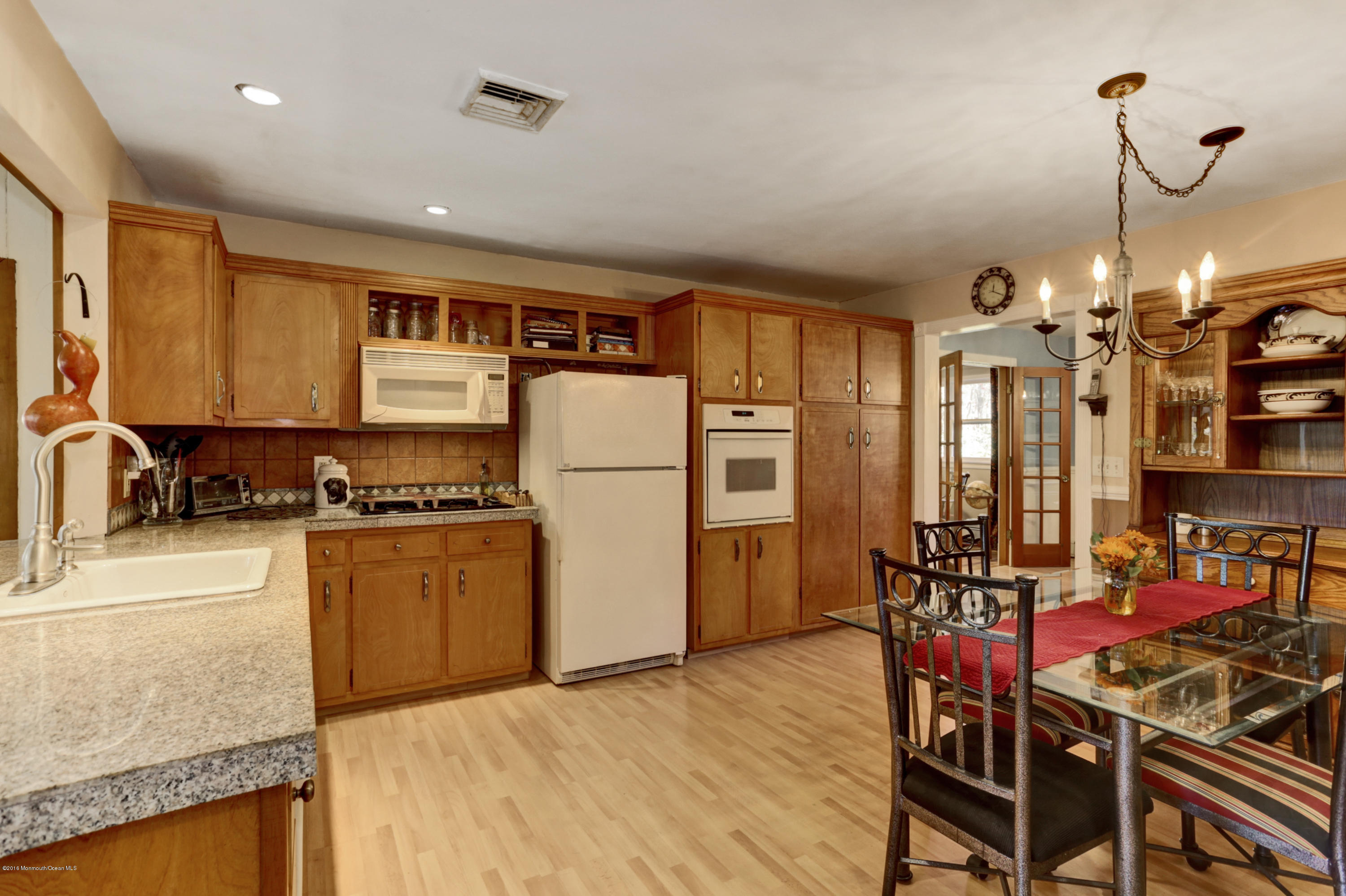 255 Portland Road Middletown, NJ 07737 - Photo 17 of 41 a kitchen with stainless steel appliances granite countertop a refrigerator a stove top oven a sink dishwasher and a dining table with wooden floor