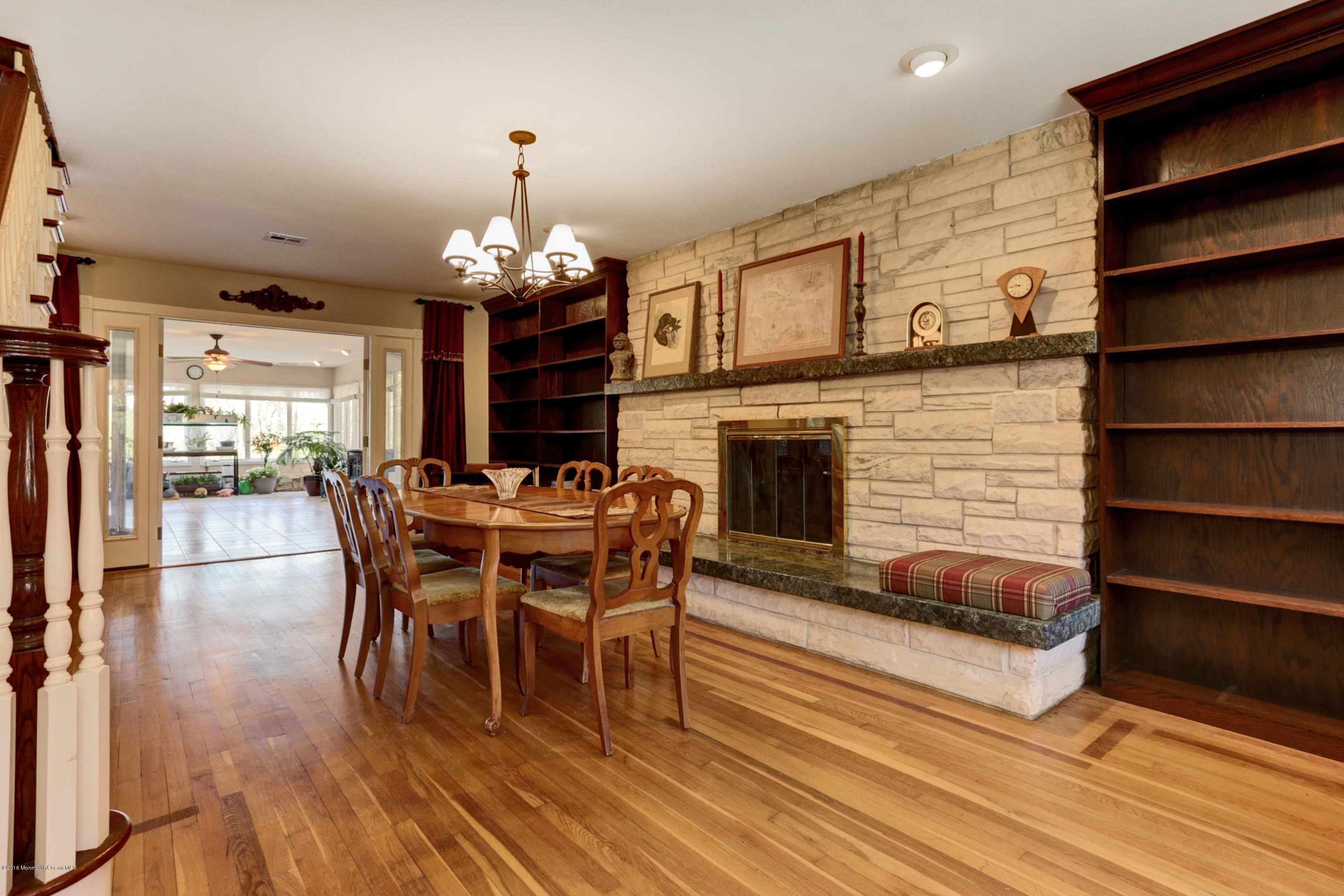 255 Portland Road Middletown, NJ 07737 - Photo 10 of 41 a dining room with wooden floor a chandelier a wooden table and chairs