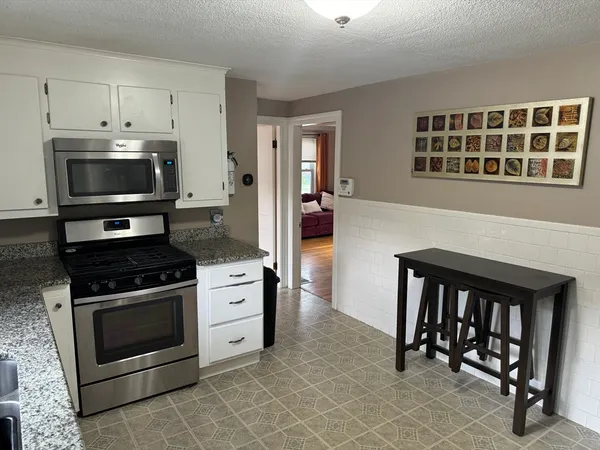 a kitchen with granite countertop a stove and a microwave