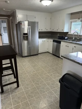 a kitchen with stainless steel appliances granite countertop a refrigerator and a stove top oven