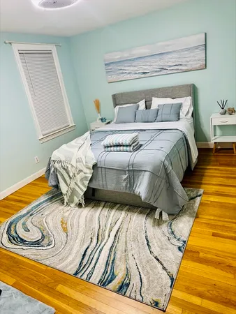a bedroom with a bed and wooden floor