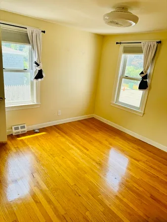 a view of a room with wooden floor and a window