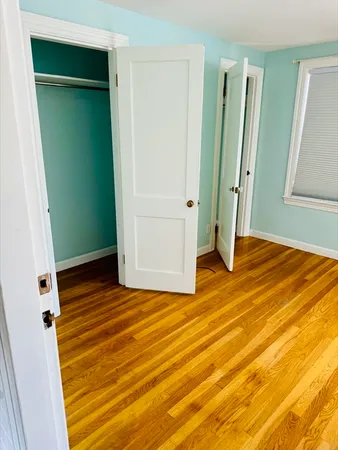 a view of empty room with wooden floor