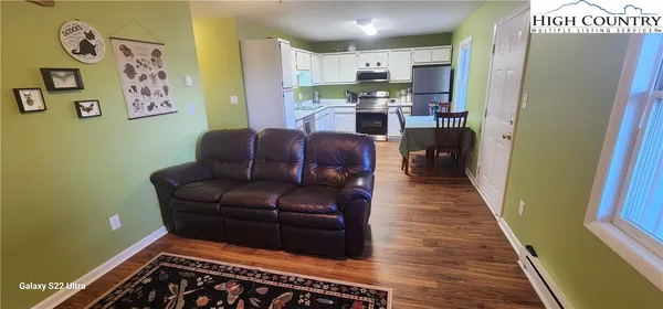 a living room with stainless steel appliances furniture and a rug