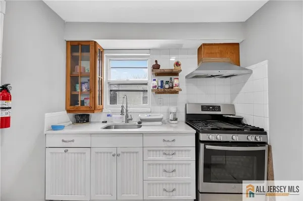a kitchen with a refrigerator and white cabinets