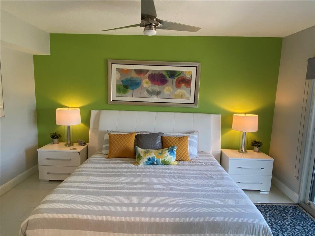 1705 North Riverside Drive, Unit 5 Pompano Beach, FL 33062 - Photo 12 of 24 a bedroom with a bed and a lamp