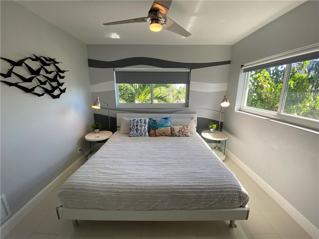1705 North Riverside Drive, Unit 5 Pompano Beach, FL 33062 - Photo 15 of 24 a bedroom with a bed and a flat screen tv