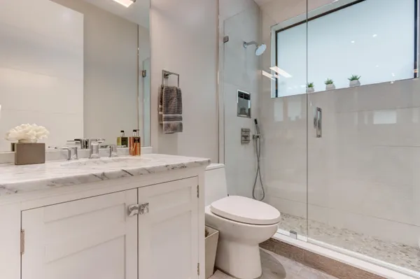 a bathroom with a sink a toilet and shower