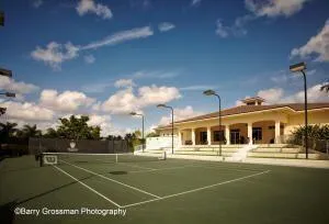 a view of a tennis ground with large trees