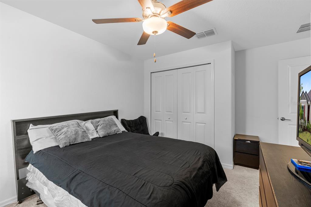 13124 Merlot Sunstone Cove Parrish, FL 34219 - Photo 19 of 45 a bedroom with a bed and a ceiling fan