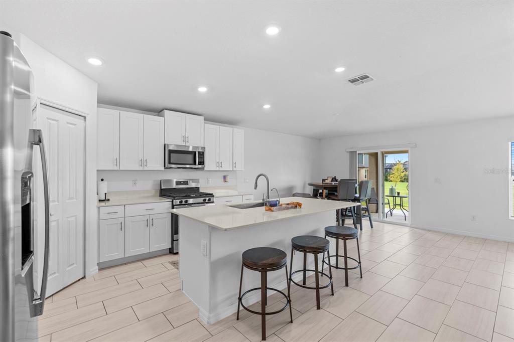 13124 Merlot Sunstone Cove Parrish, FL 34219 - Photo 24 of 45 a kitchen with appliances cabinets and chairs