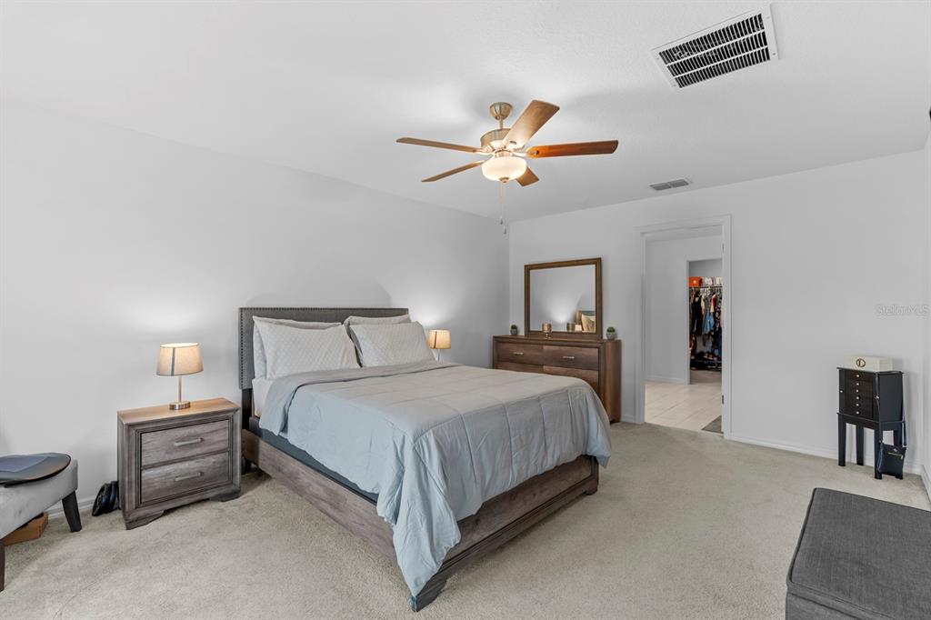 13124 Merlot Sunstone Cove Parrish, FL 34219 - Photo 33 of 45 a bedroom with a bed and a chandelier