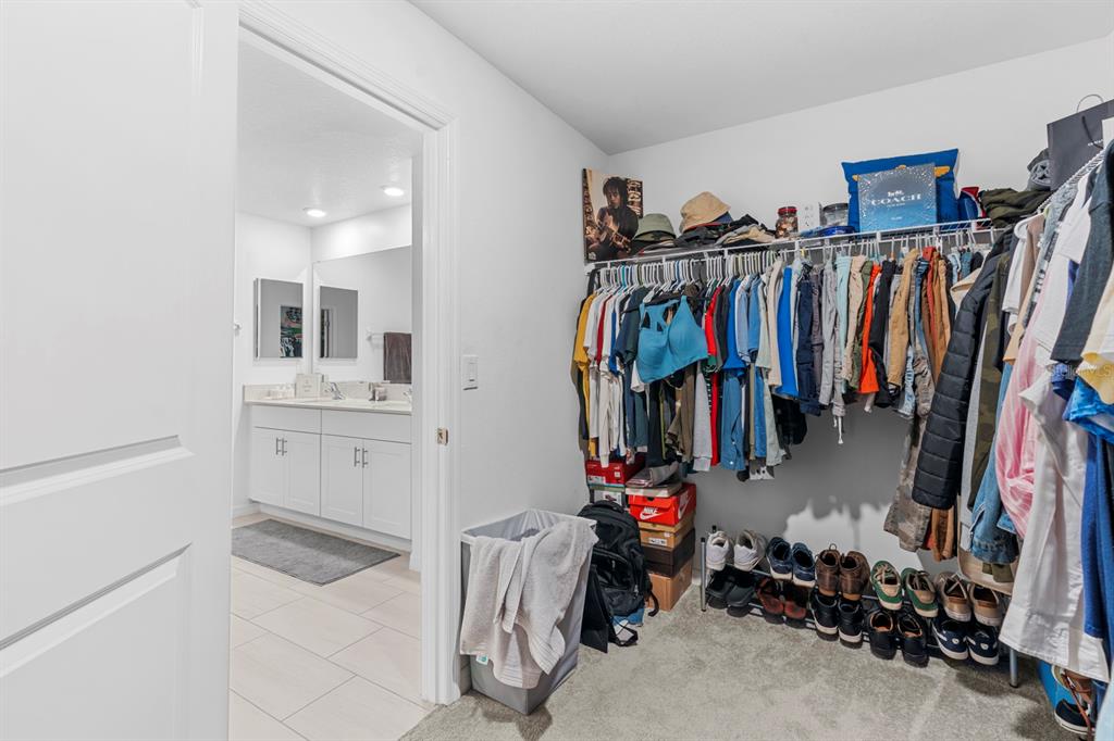 13124 Merlot Sunstone Cove Parrish, FL 34219 - Photo 38 of 45 a view of walk in closet with clothes