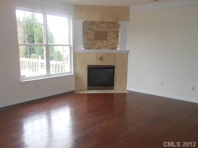 13502 Latta Gordon Road Huntersville, NC 28078 - Photo 3 of 7 an empty room with wooden floor fireplace and windows