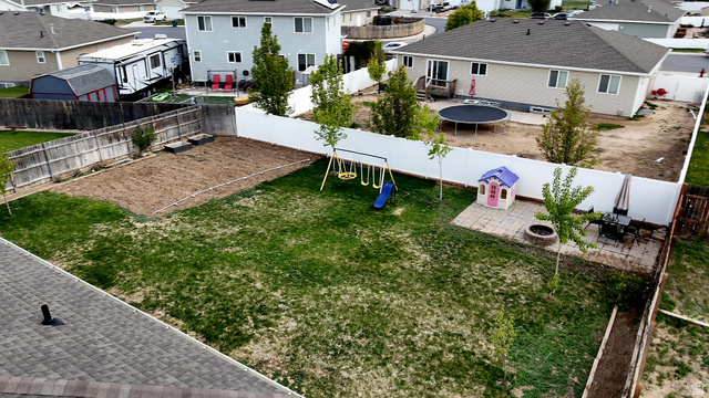 1437 925 South Vernal, UT 84078 - Photo 44 of 47 Expansive fenced backyard featuring a grassy lawn area, a designated garden plot, and a paved patio area