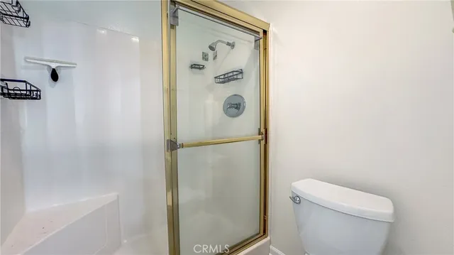 a bathroom with a shower a toilet and a mirror