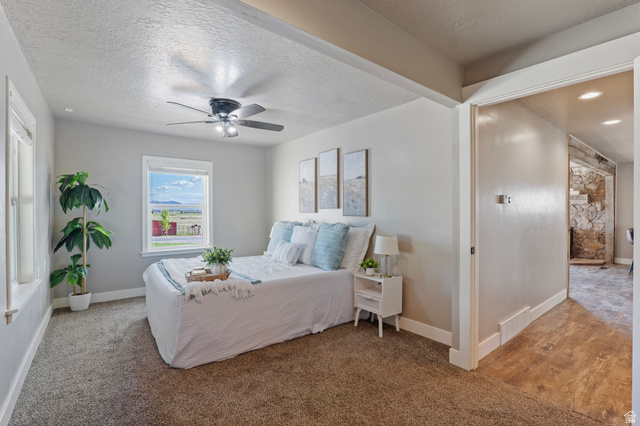 115 East 1600th Street North Santaquin, UT 84655 - Photo 10 of 52 Carpeted room featuring a ceiling fan with integrated lighting, a window with exterior views, and a doorway opening to a wood-finish floor