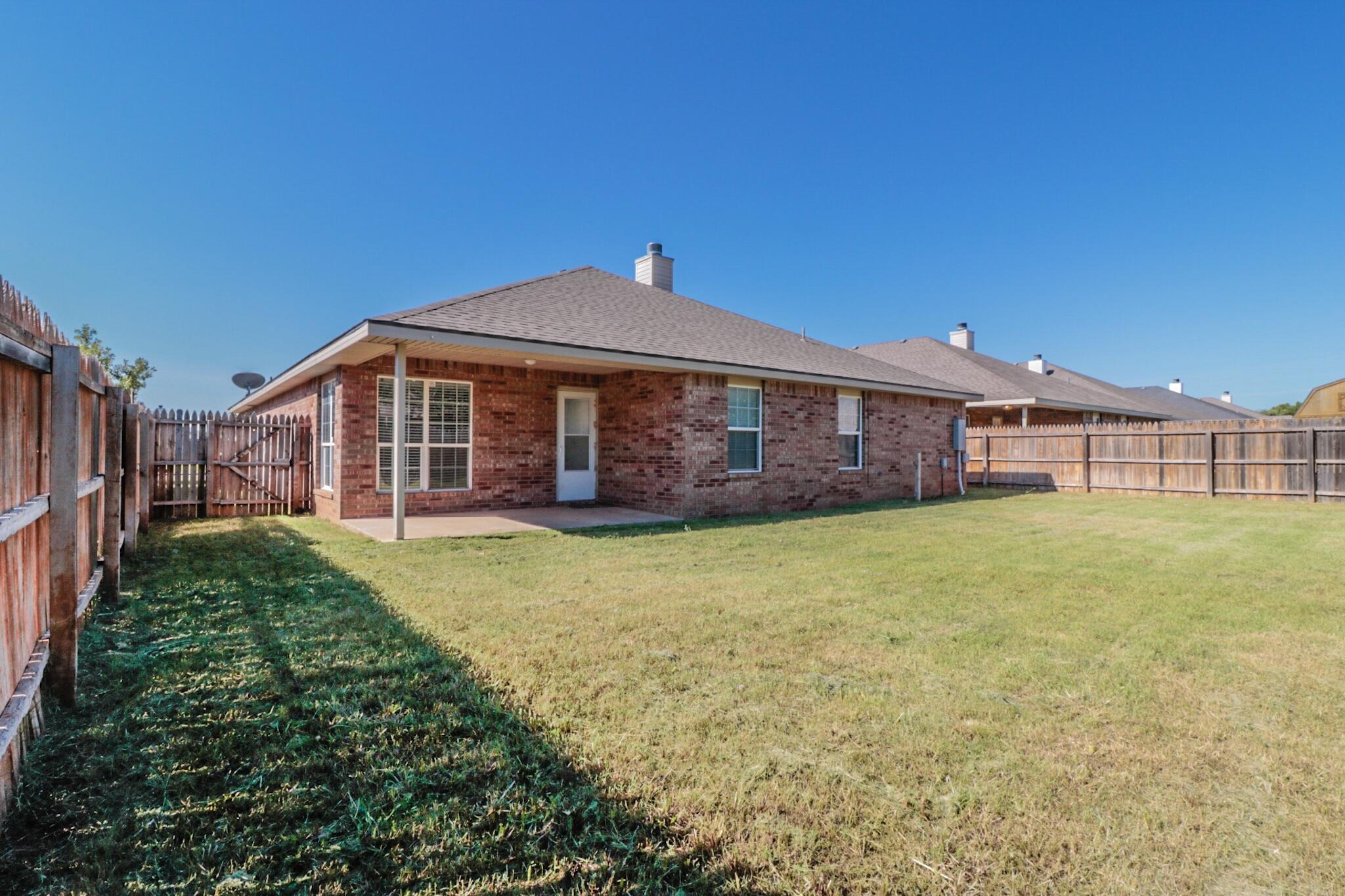 6808 88th Street Lubbock, TX 79424 - Photo 16 of 17 a front view of a house with a garden