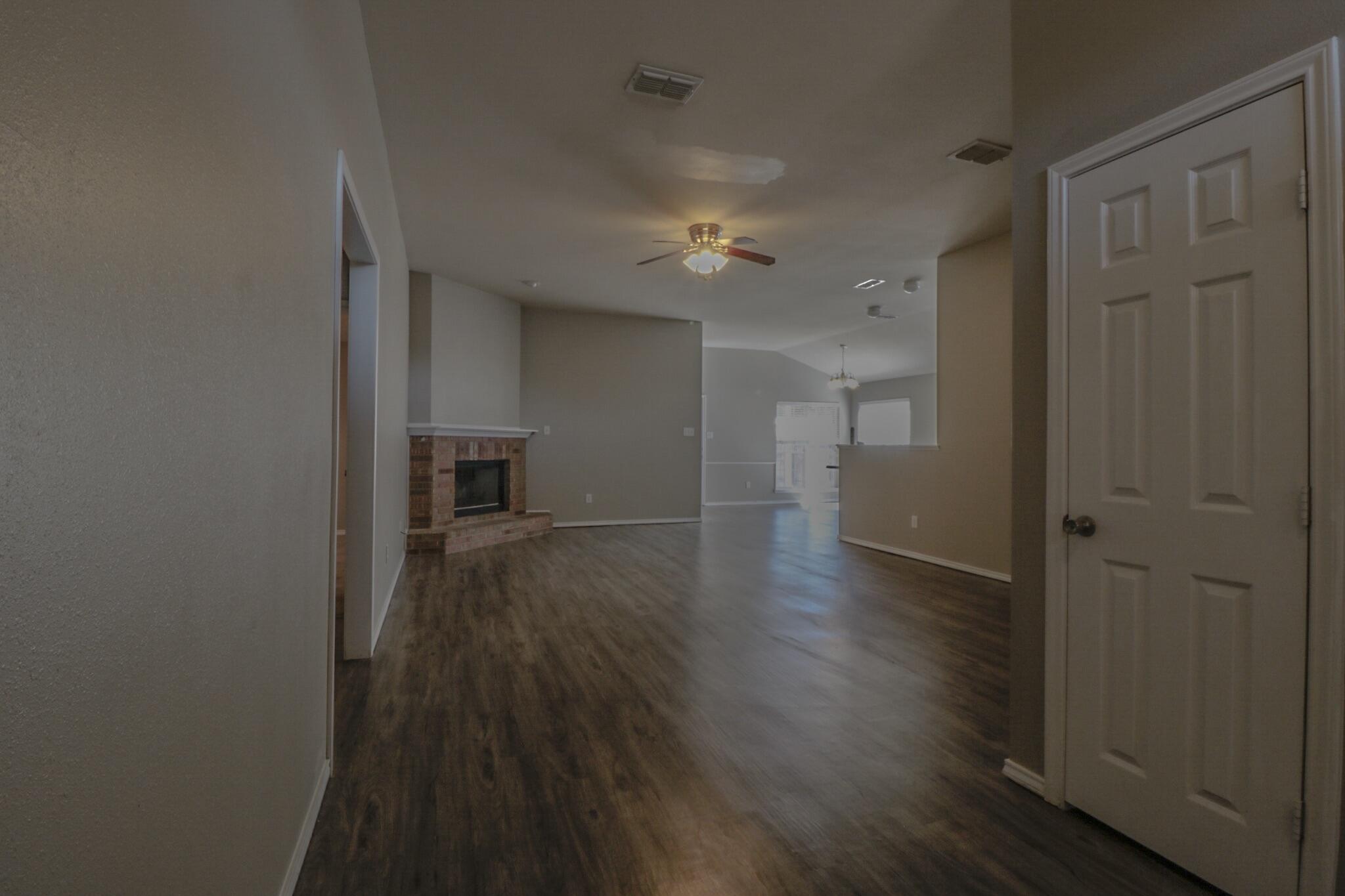 6808 88th Street Lubbock, TX 79424 - Photo 2 of 17 a view of a hallway with wooden floor and a bathroom