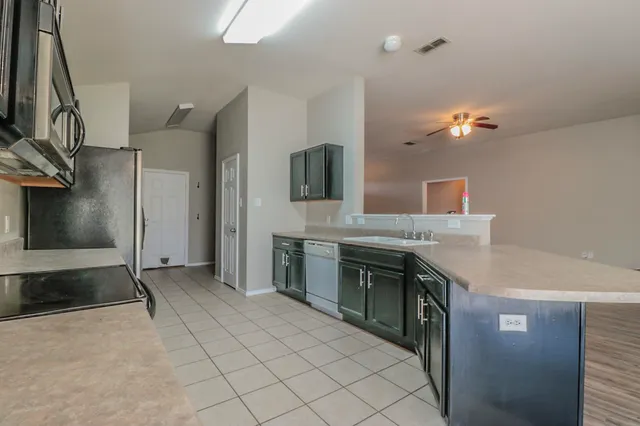 a kitchen with stainless steel appliances granite countertop a sink and a stove